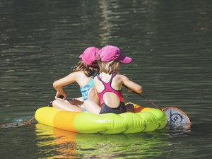 Kinder auf einer Luftmatratze auf dem Badesee
